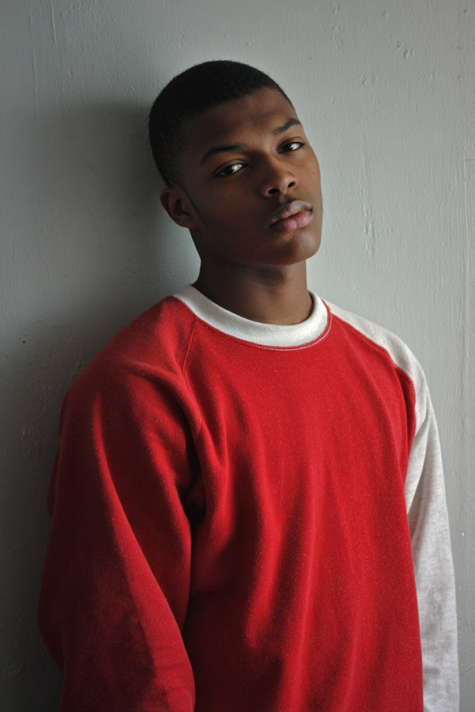 a portrait of a black man in red hoodie 