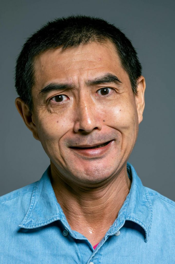 a portrait of an asian man in jeans shirt